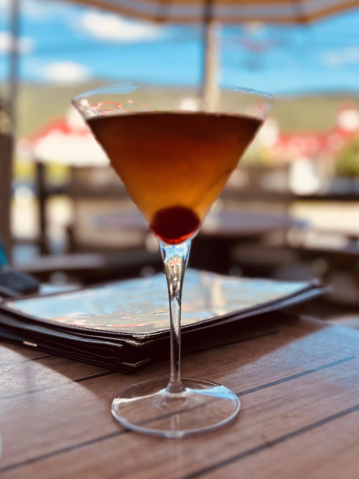 Craft cocktail on an outdoor restaurant patio with mountain views